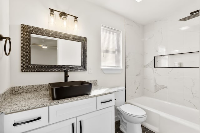 full bathroom featuring vanity, tiled shower / bath, and toilet