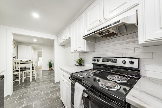 kitchen with light stone counters, electric range, tasteful backsplash, and white cabinets