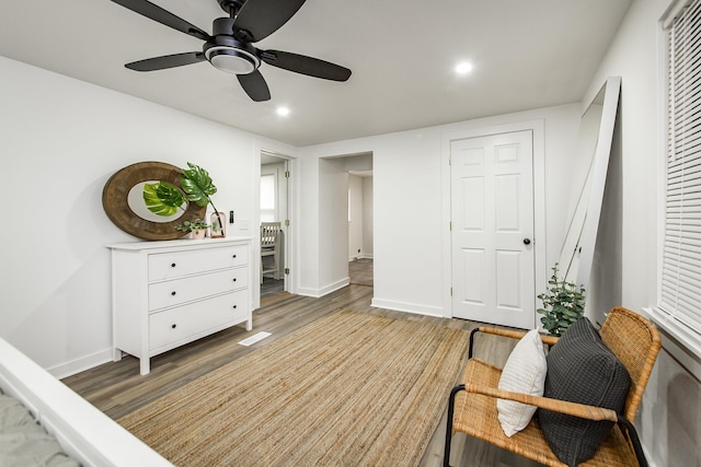 sitting room featuring dark wood-type flooring and ceiling fan