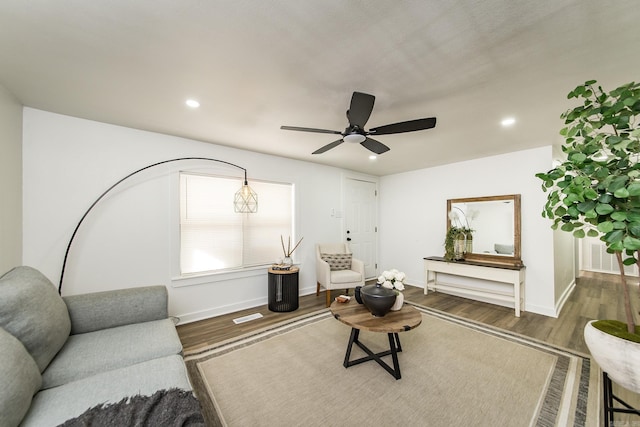 living room featuring dark hardwood / wood-style flooring and ceiling fan