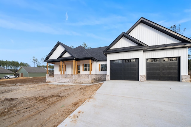 modern farmhouse style home featuring driveway, covered porch, and a garage