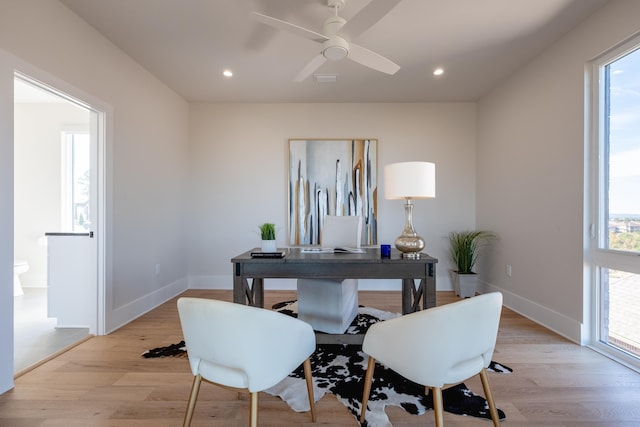 home office with light hardwood / wood-style flooring and ceiling fan