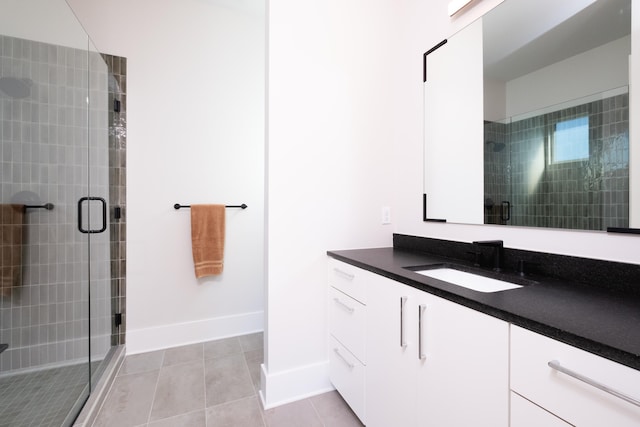 bathroom featuring tile patterned flooring, vanity, and walk in shower