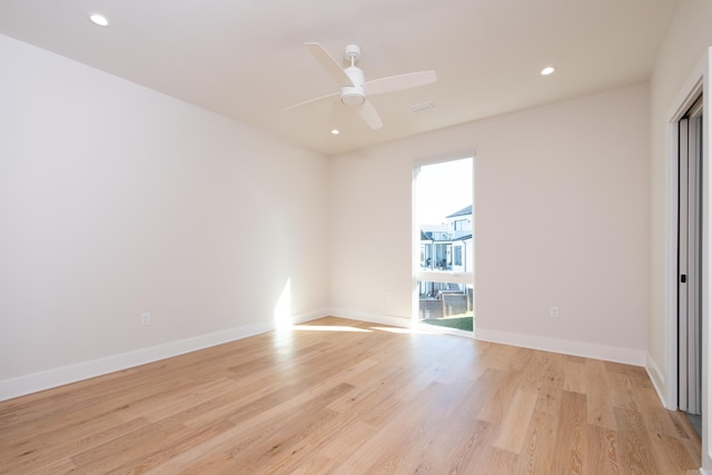 spare room featuring a wealth of natural light, light hardwood / wood-style flooring, and ceiling fan