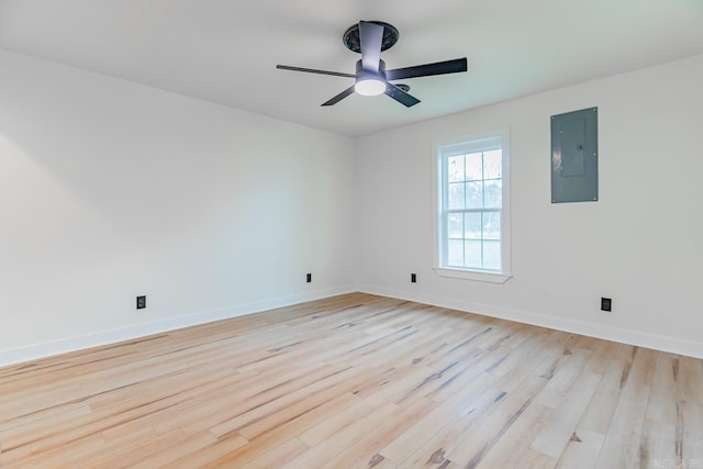 empty room featuring ceiling fan, electric panel, and light wood-type flooring