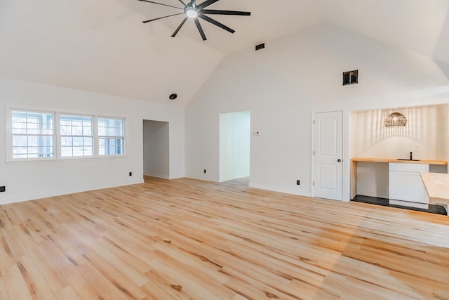 unfurnished living room with ceiling fan, high vaulted ceiling, and light wood-type flooring