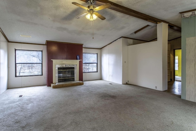 unfurnished living room featuring a fireplace, carpet floors, vaulted ceiling with beams, crown molding, and a textured ceiling