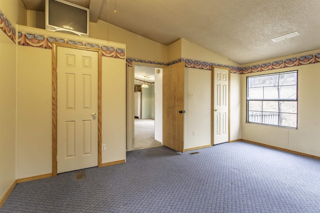 carpeted spare room with lofted ceiling and a textured ceiling