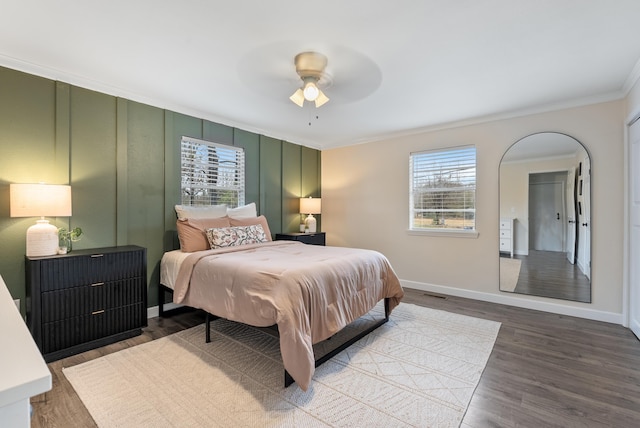 bedroom featuring hardwood / wood-style flooring, ornamental molding, and ceiling fan