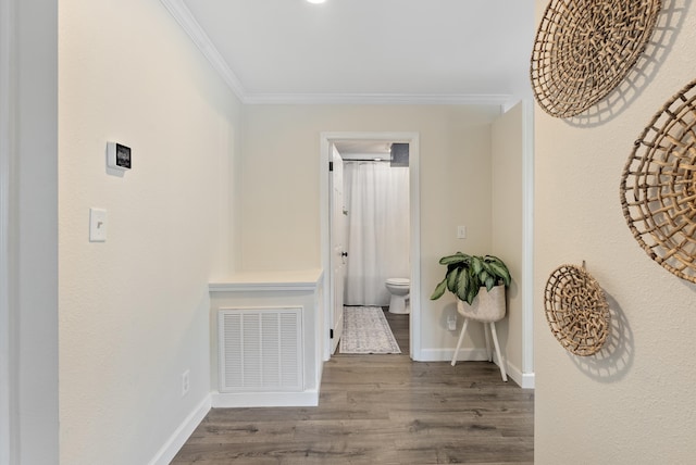 hall with dark wood-type flooring and ornamental molding