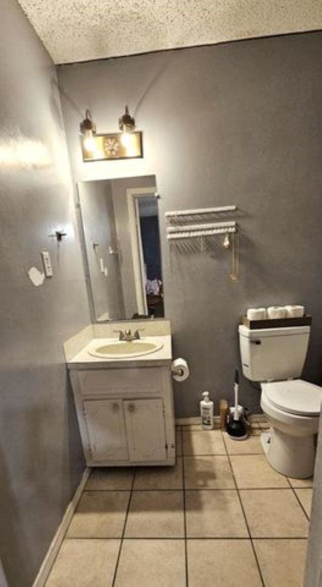 bathroom with tile patterned flooring, vanity, and toilet