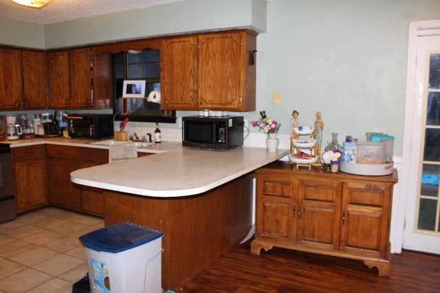 kitchen featuring tile patterned floors, kitchen peninsula, and a textured ceiling