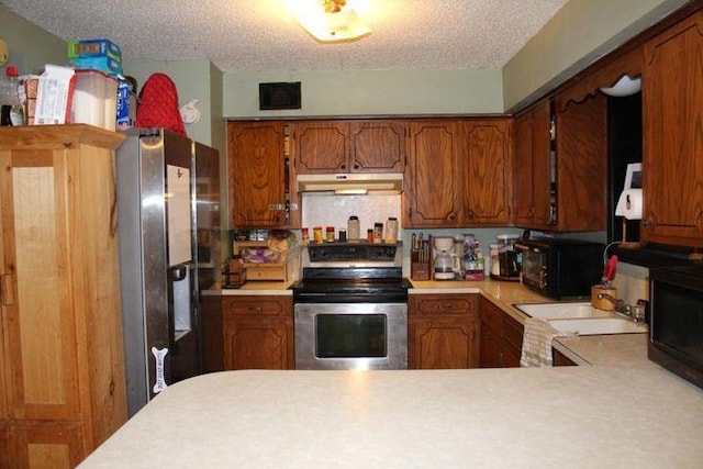 kitchen featuring appliances with stainless steel finishes, kitchen peninsula, and a textured ceiling