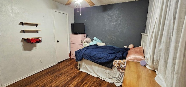 bedroom with dark hardwood / wood-style flooring and ceiling fan