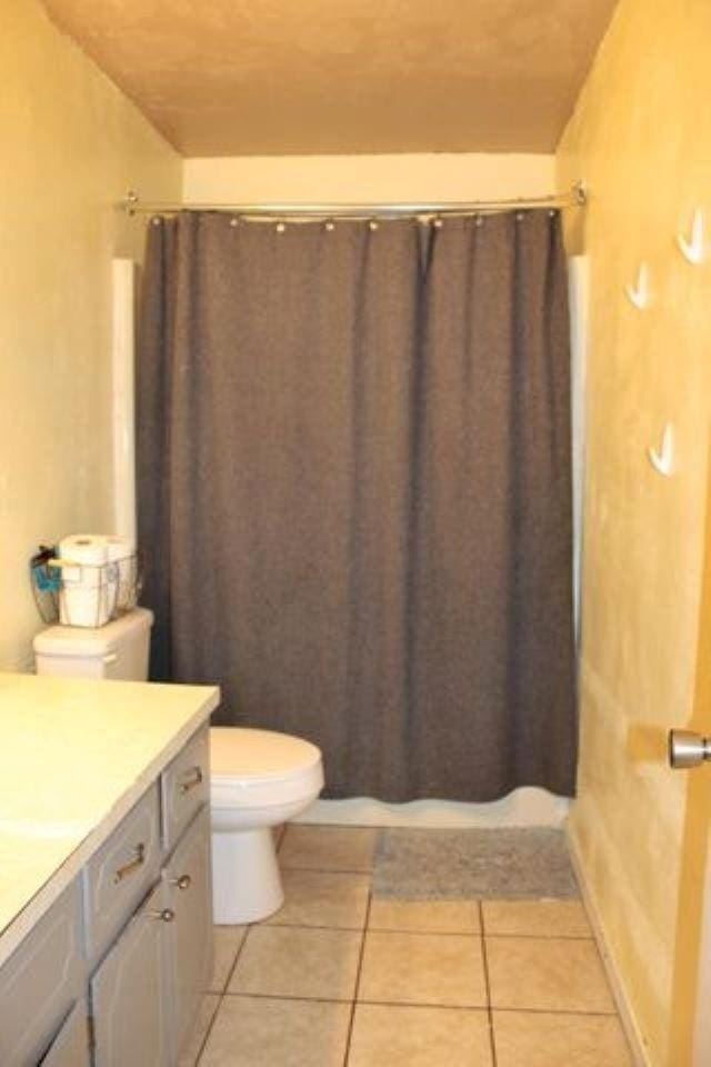 bathroom with vanity, a shower with curtain, tile patterned floors, and toilet