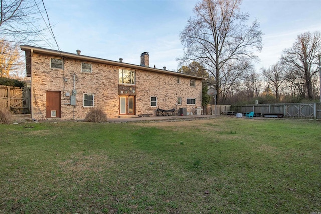 back of property featuring a patio area and a lawn