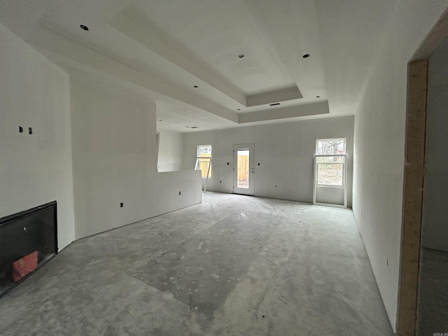 unfurnished living room featuring a tray ceiling