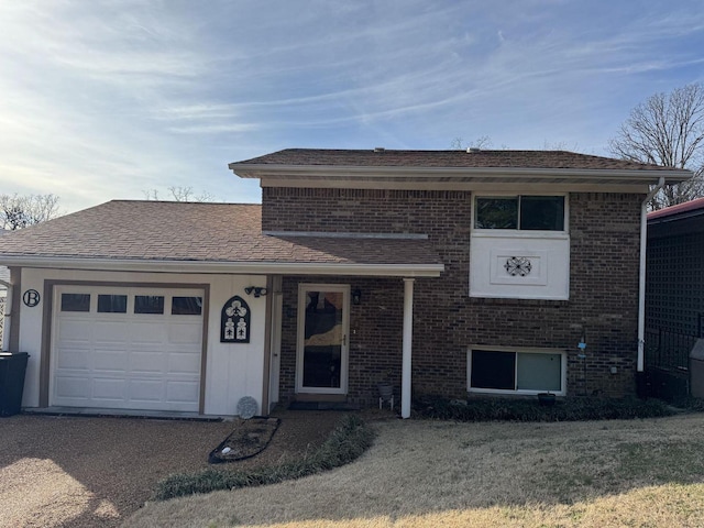 tri-level home with a garage and a front yard