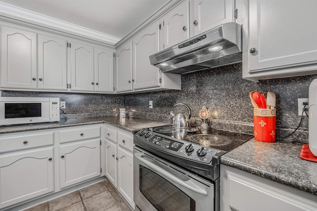 kitchen with decorative backsplash, white cabinets, and stainless steel electric range oven