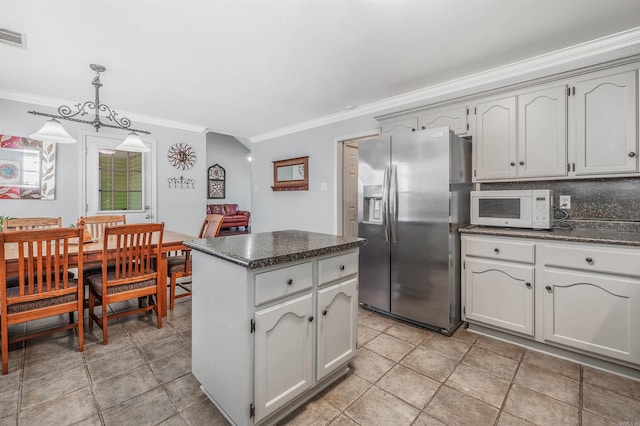 kitchen featuring decorative light fixtures, stainless steel fridge, decorative backsplash, a center island, and crown molding