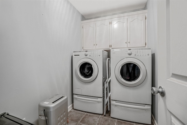 washroom featuring cabinets, washing machine and dryer, and light tile patterned flooring