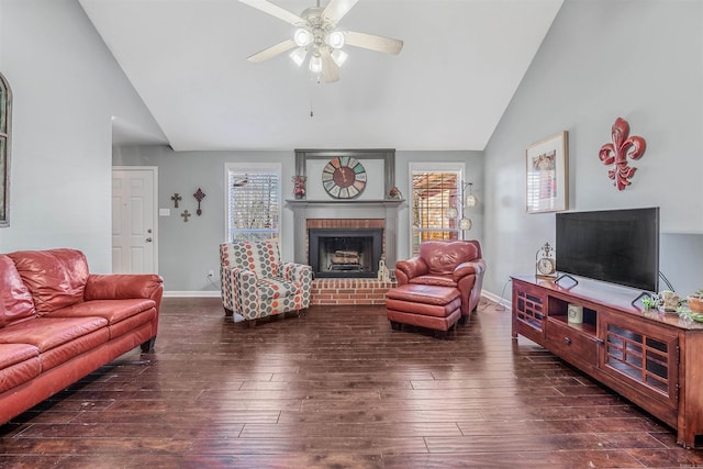 living room with a brick fireplace, dark hardwood / wood-style floors, a healthy amount of sunlight, and ceiling fan