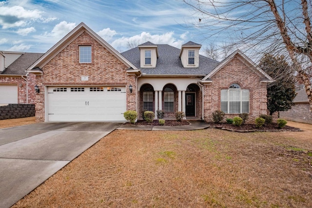 front of property with a garage, a front yard, and covered porch