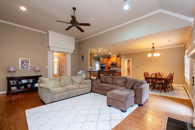 living room featuring ornate columns, crown molding, high vaulted ceiling, hardwood / wood-style floors, and ceiling fan with notable chandelier