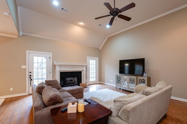 living room featuring crown molding, wood-type flooring, high vaulted ceiling, and ceiling fan