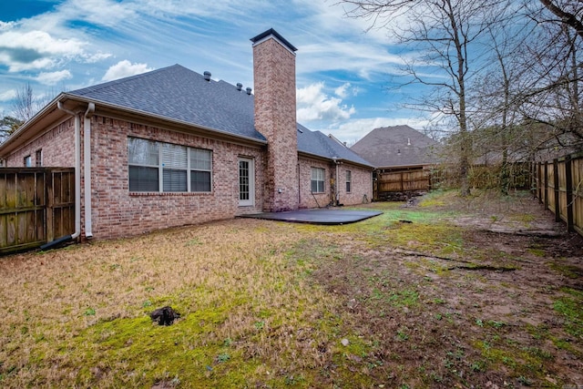 rear view of property with a patio and a lawn