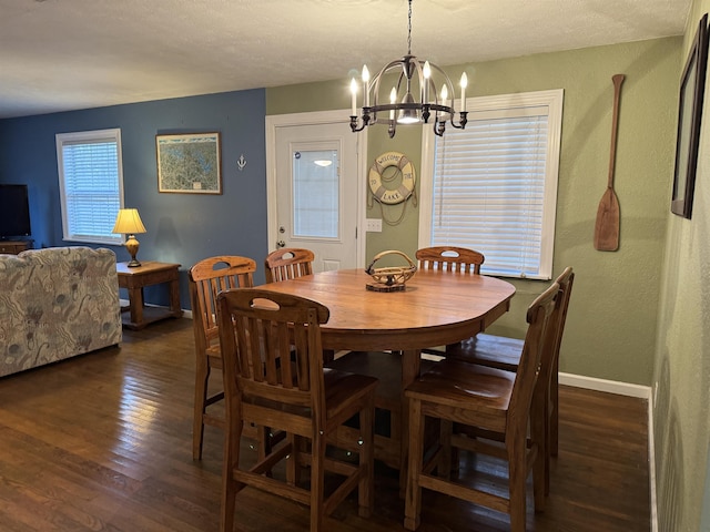 dining area featuring dark hardwood / wood-style flooring and a chandelier