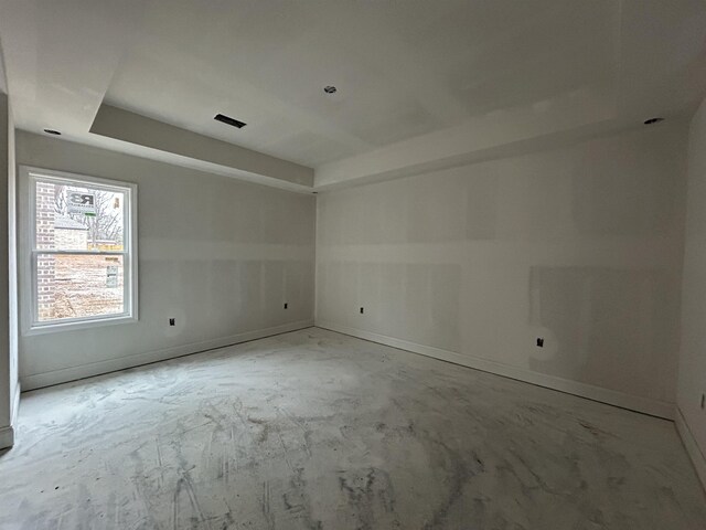 unfurnished room featuring a tray ceiling