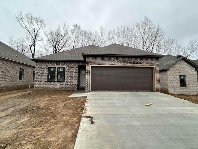 view of front of home featuring a garage, brick siding, concrete driveway, and a shingled roof