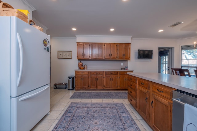 kitchen featuring light tile patterned flooring, white fridge, and crown molding