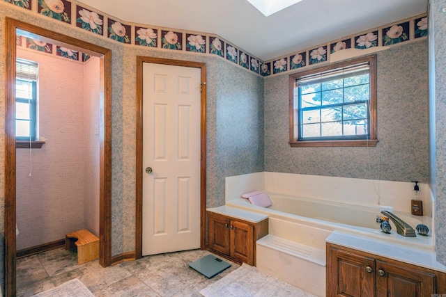 bathroom with plenty of natural light, a bath, and a skylight