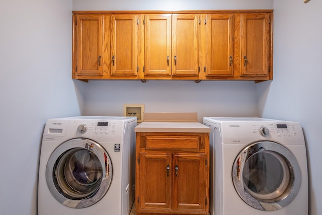 laundry area featuring washer and dryer and cabinets