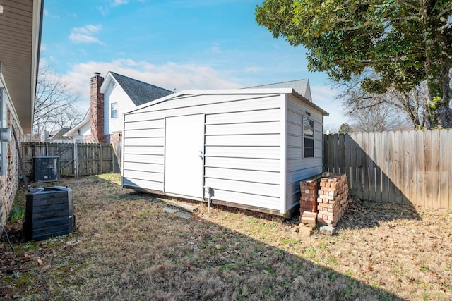 view of outdoor structure with a yard and central air condition unit