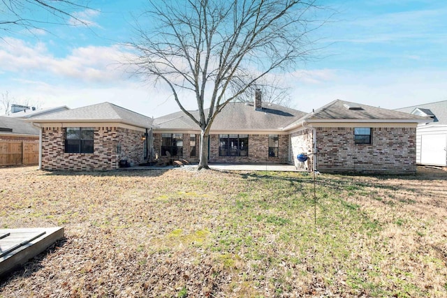 rear view of property with a yard and a patio