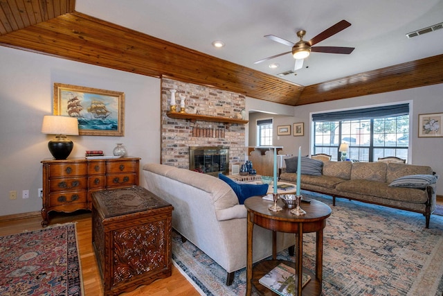 living room featuring a fireplace, lofted ceiling, hardwood / wood-style flooring, ceiling fan, and wooden ceiling