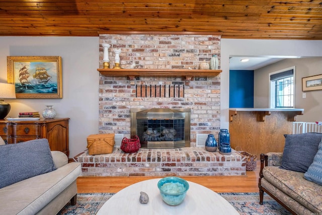 living room with hardwood / wood-style flooring, wood ceiling, and a fireplace