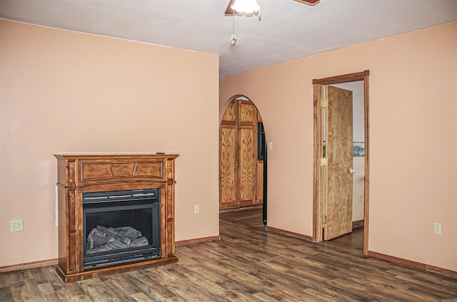 unfurnished living room with ceiling fan and dark hardwood / wood-style floors