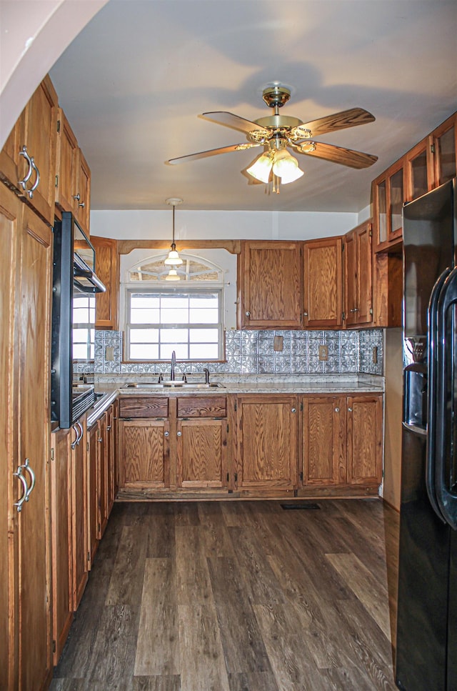 kitchen featuring tasteful backsplash, sink, black fridge with ice dispenser, and dark wood-type flooring