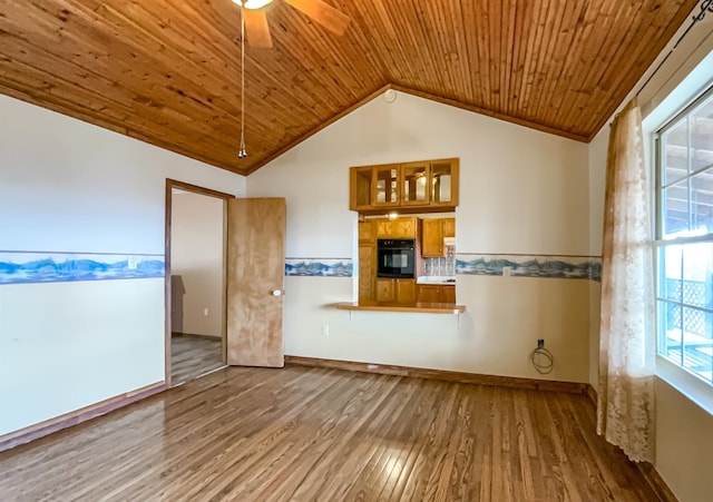 empty room with hardwood / wood-style flooring, vaulted ceiling, a wealth of natural light, and wood ceiling