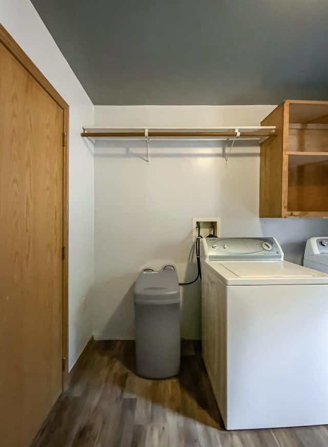 clothes washing area featuring dark hardwood / wood-style floors and washer and clothes dryer