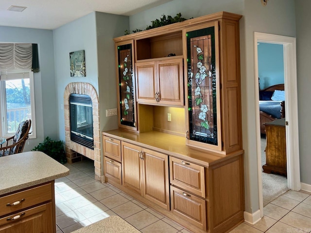 kitchen featuring light tile patterned floors and a fireplace