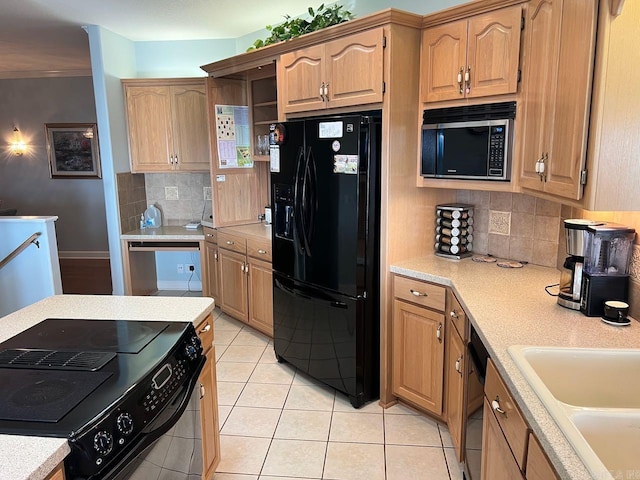 kitchen with tasteful backsplash, light tile patterned floors, black appliances, and sink