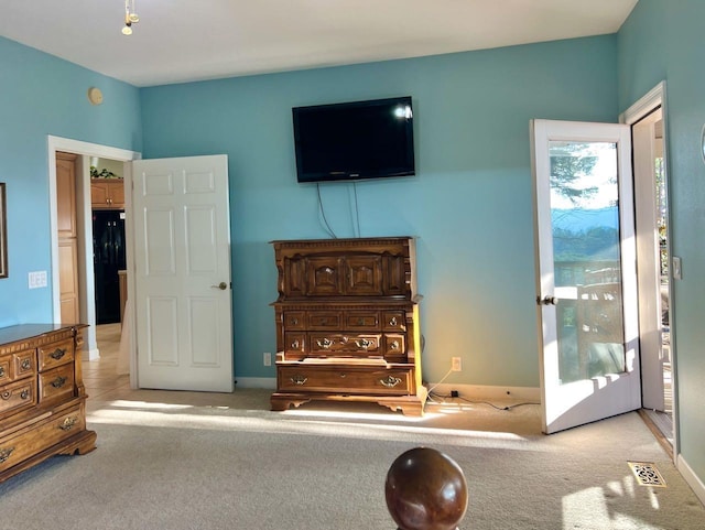 bedroom with black refrigerator and light carpet