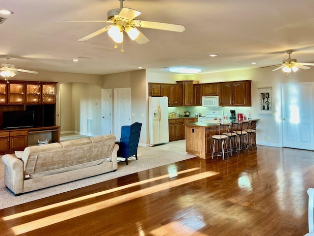 living room featuring wood-type flooring and ceiling fan
