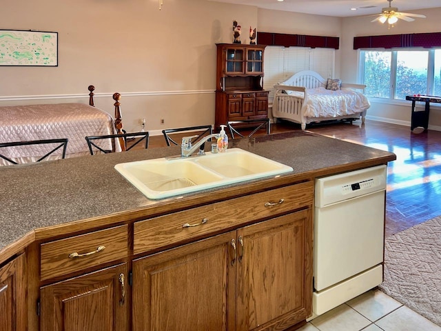 kitchen with white dishwasher, sink, light tile patterned floors, and ceiling fan