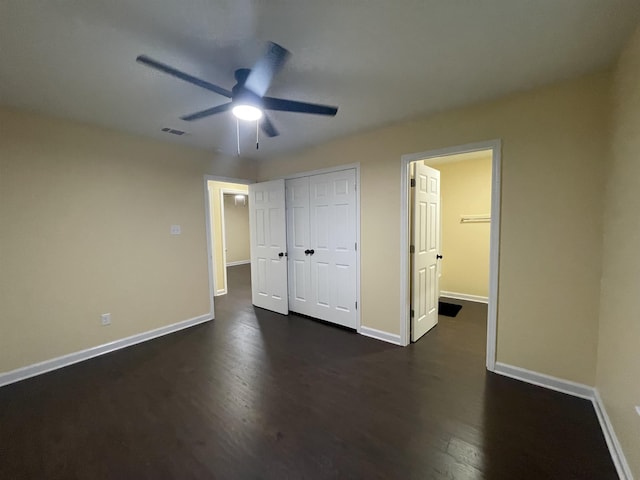 unfurnished bedroom with ceiling fan, dark hardwood / wood-style flooring, and a closet